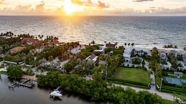 aerial view at dusk featuring a water view