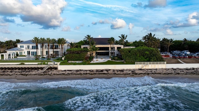 rear view of property featuring a water view and a beach view