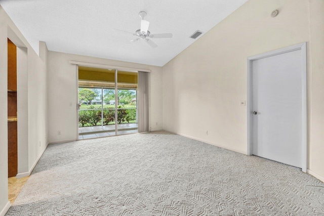 empty room featuring light carpet, a textured ceiling, vaulted ceiling, and ceiling fan