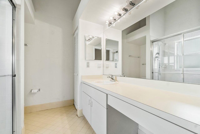 bathroom with tile patterned flooring, vanity, and an enclosed shower