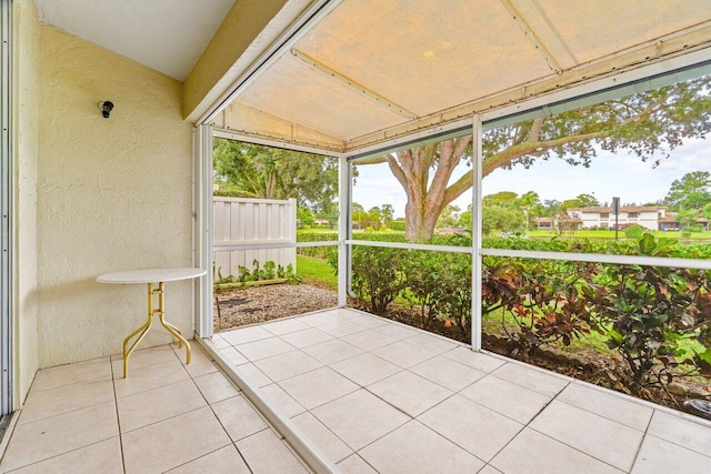 unfurnished sunroom featuring vaulted ceiling