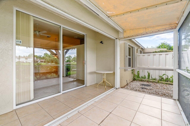 unfurnished sunroom with ceiling fan