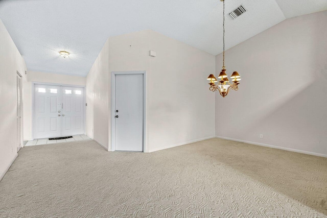 carpeted empty room featuring lofted ceiling and a notable chandelier