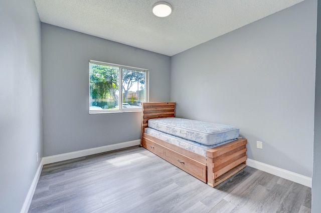 bedroom featuring a textured ceiling and hardwood / wood-style flooring