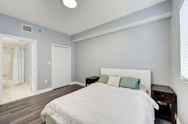 bedroom with connected bathroom and dark hardwood / wood-style flooring