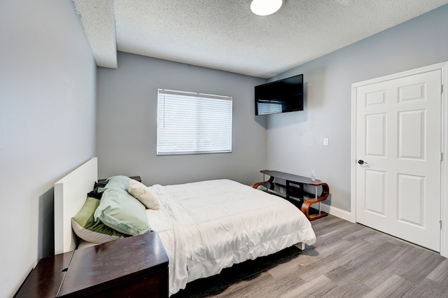 bedroom featuring a textured ceiling and light wood-type flooring