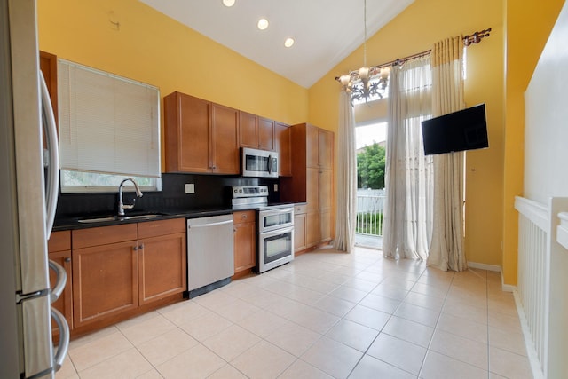 kitchen with a chandelier, hanging light fixtures, stainless steel appliances, decorative backsplash, and sink