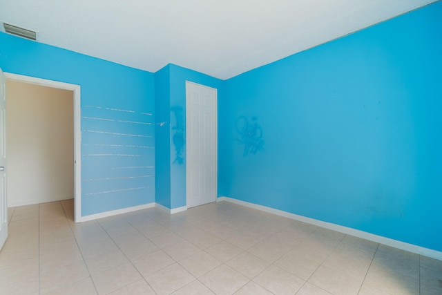 unfurnished bedroom with light tile patterned flooring and a closet