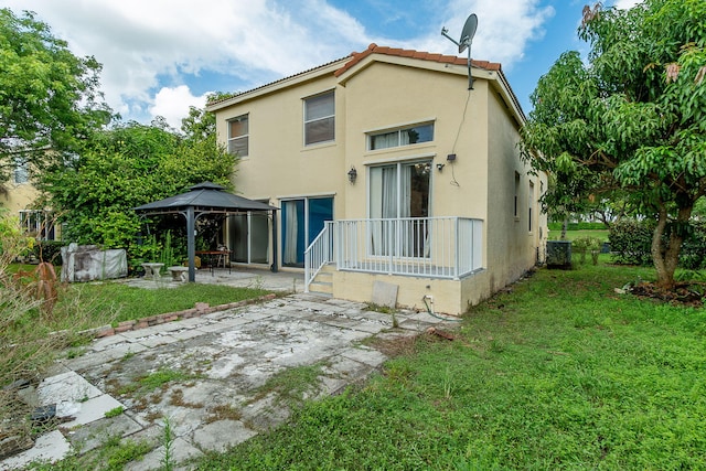 rear view of property featuring a patio area, a gazebo, a lawn, and central air condition unit