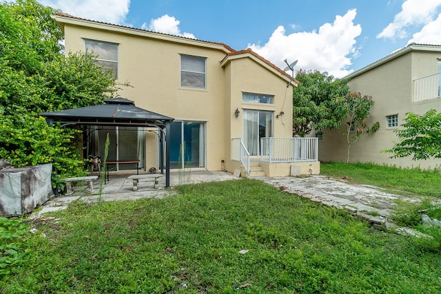 back of house with a yard and a gazebo