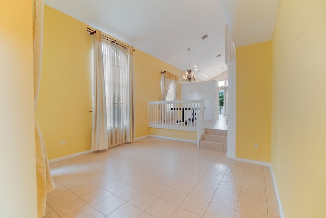 spare room featuring an inviting chandelier, light tile patterned floors, and vaulted ceiling