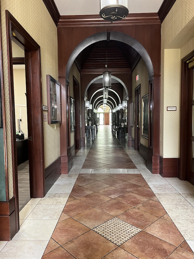 hall featuring light tile patterned flooring and crown molding