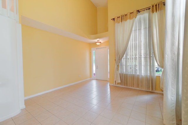 tiled spare room with a high ceiling