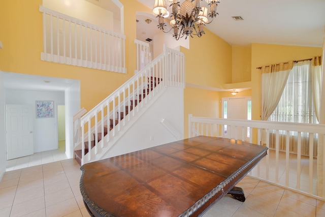 dining space featuring an inviting chandelier, light tile patterned floors, and high vaulted ceiling