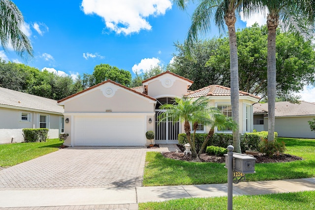 mediterranean / spanish-style house featuring a garage and a front yard