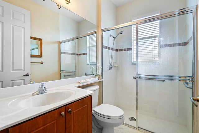 bathroom featuring vanity, an enclosed shower, and toilet