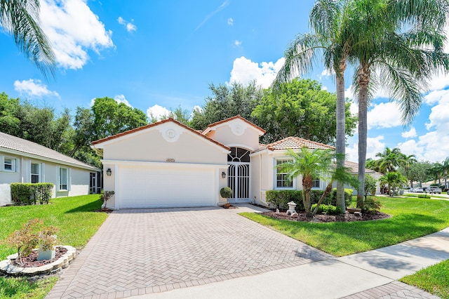 mediterranean / spanish-style home featuring a garage and a front yard