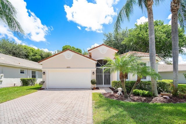 mediterranean / spanish-style house featuring a garage and a front lawn