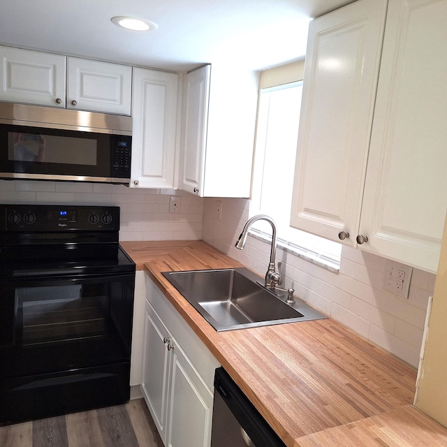 kitchen featuring sink, stainless steel appliances, butcher block countertops, backsplash, and white cabinets