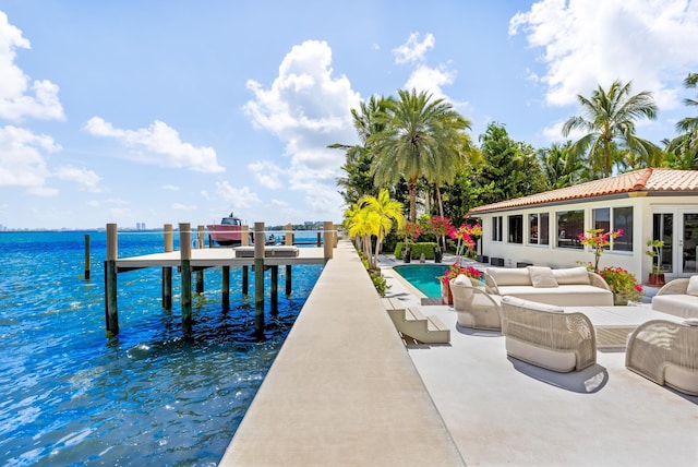 view of dock featuring outdoor lounge area, a water view, and a patio