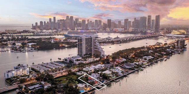 aerial view at dusk featuring a water view