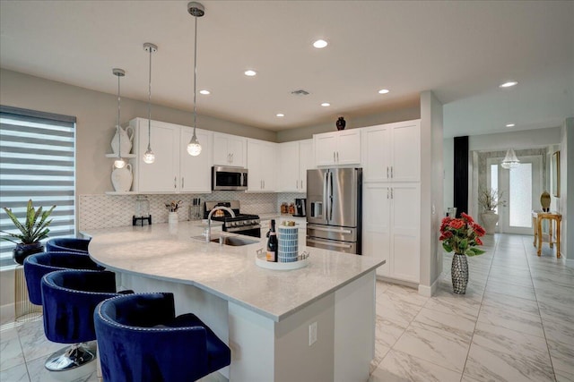 kitchen featuring stainless steel appliances, sink, kitchen peninsula, and white cabinets