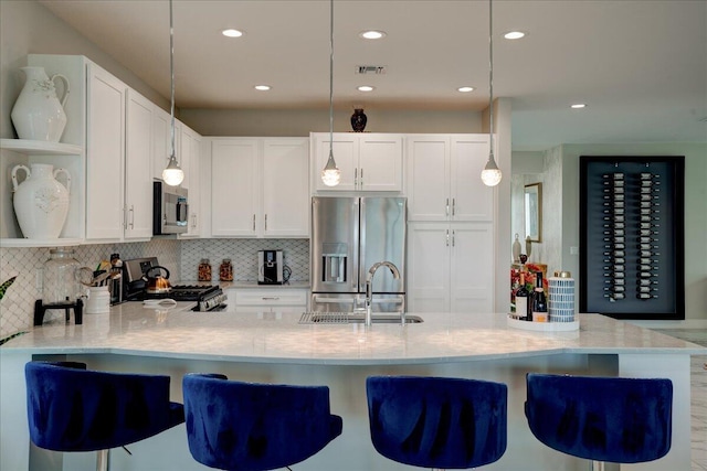 kitchen with white cabinetry, stainless steel appliances, tasteful backsplash, and pendant lighting