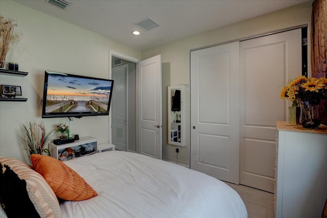 bedroom with a closet and light tile patterned flooring