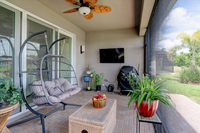 sunroom with a healthy amount of sunlight and ceiling fan