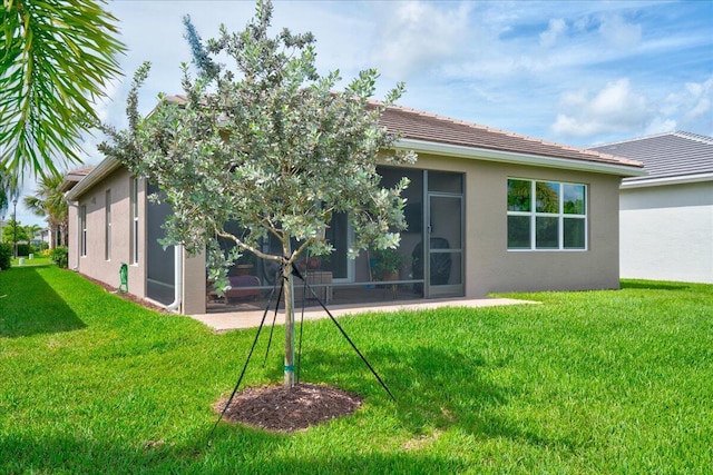 back of property with a patio area and a lawn