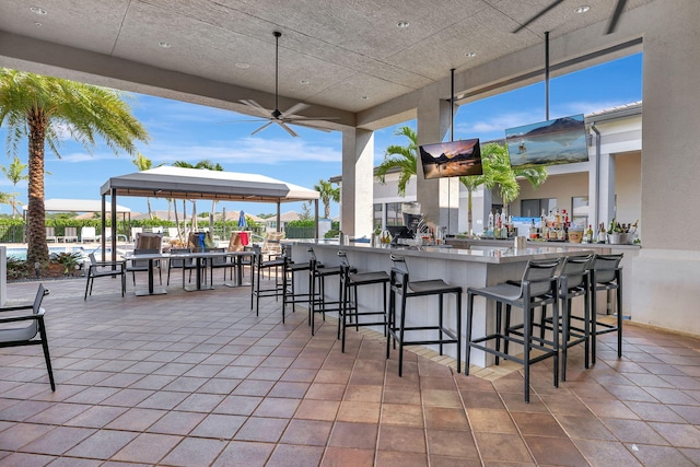 view of patio / terrace featuring an outdoor bar and ceiling fan