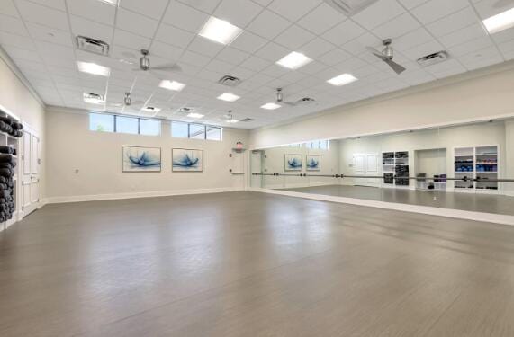 workout room with ceiling fan and a drop ceiling