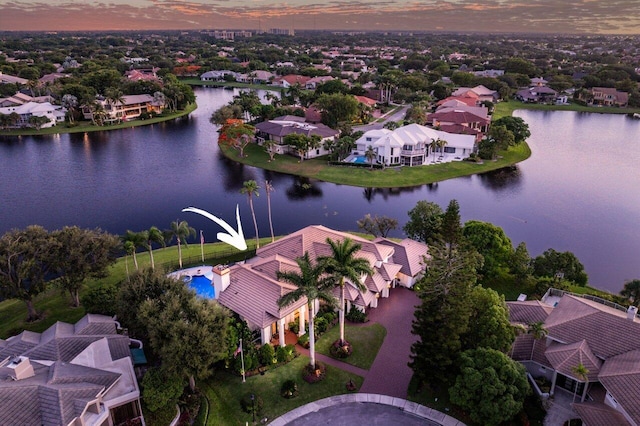 aerial view at dusk featuring a water view