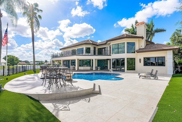 back of property with a patio, a balcony, fence, a fenced in pool, and stucco siding