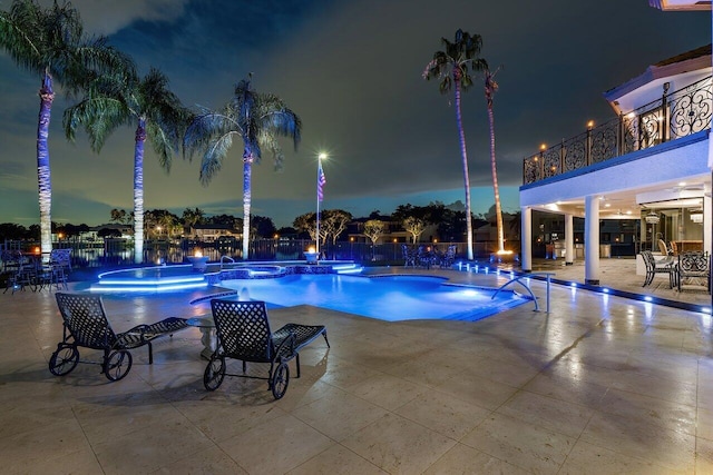 pool at twilight with a patio area, a community pool, and fence