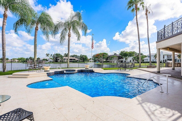 view of swimming pool with a patio area, a pool with connected hot tub, and fence