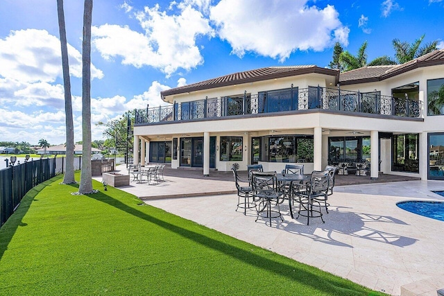 back of house featuring a patio area, a fenced backyard, a balcony, and stucco siding