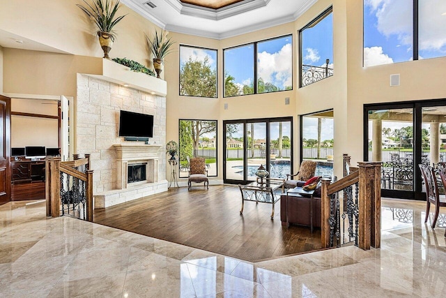 living area with ornamental molding, marble finish floor, visible vents, and a fireplace