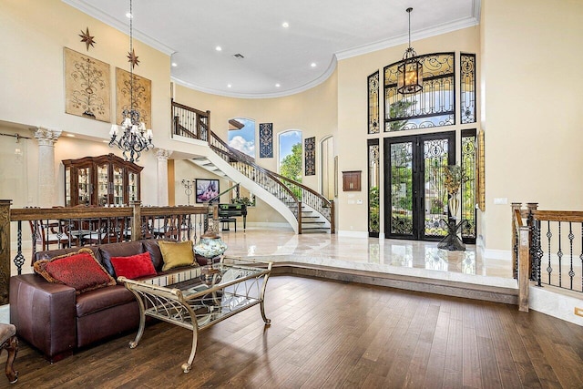 living room with french doors, decorative columns, hardwood / wood-style floors, and stairs