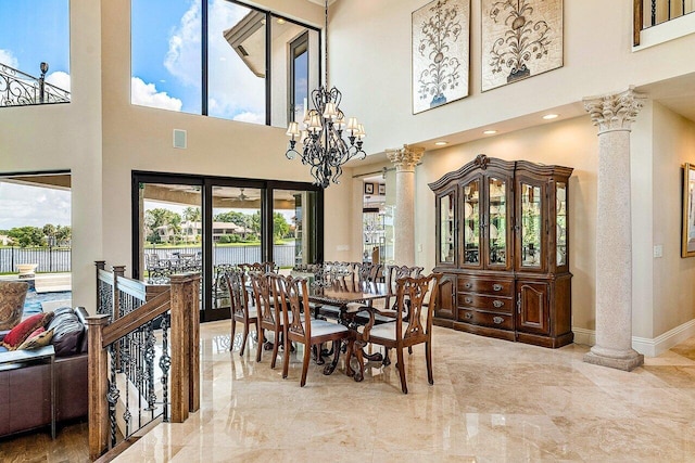 dining space with a notable chandelier, marble finish floor, and ornate columns