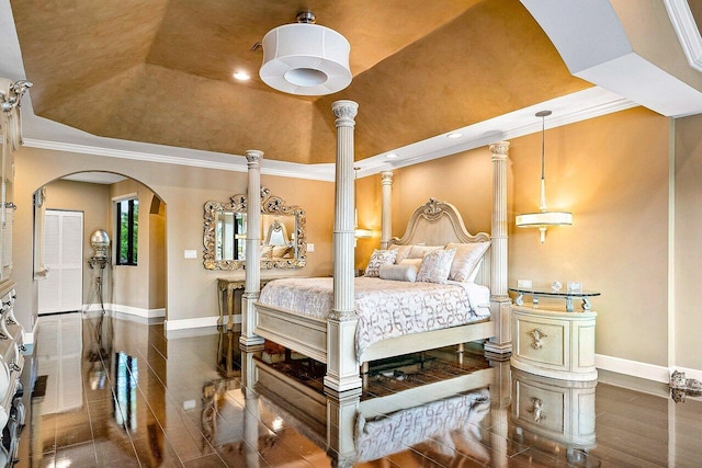 bedroom with arched walkways, a raised ceiling, crown molding, and baseboards