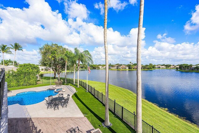 view of swimming pool with a patio, a water view, and a yard