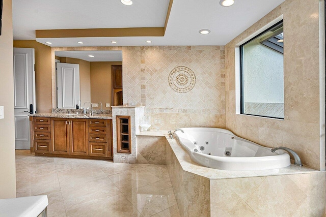 full bath with a jetted tub, recessed lighting, tile walls, and vanity