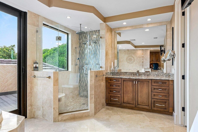 bathroom featuring tile walls, recessed lighting, visible vents, a shower stall, and vanity