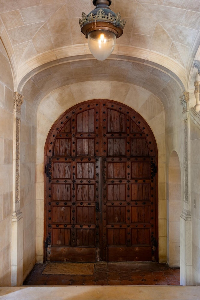 wine area with arched walkways and lofted ceiling