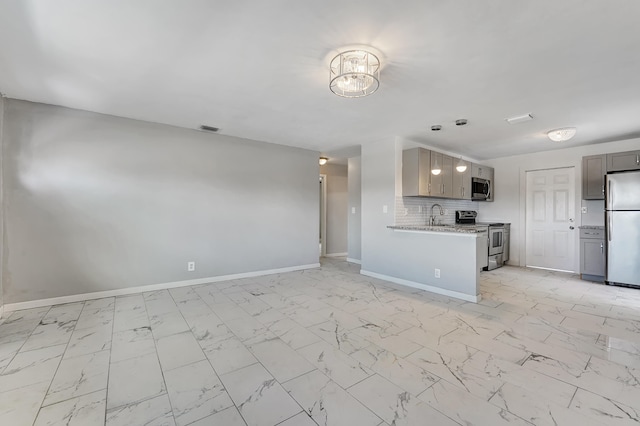 kitchen featuring appliances with stainless steel finishes, backsplash, pendant lighting, sink, and light tile floors