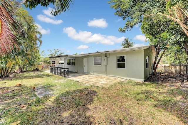 back of house with a yard and a patio area