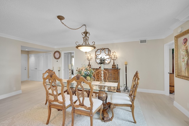 dining room featuring light wood-type flooring and crown molding