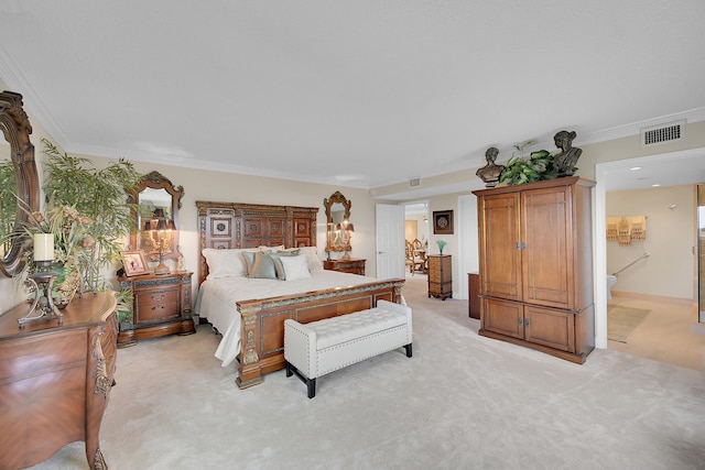 carpeted bedroom featuring ensuite bath and crown molding