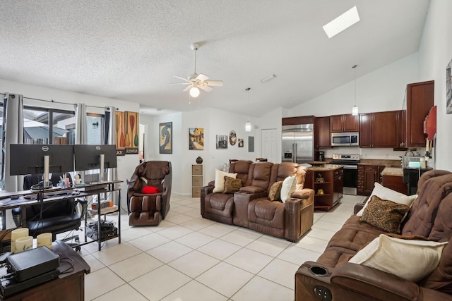 living room featuring light tile patterned flooring, a textured ceiling, ceiling fan, and vaulted ceiling with skylight